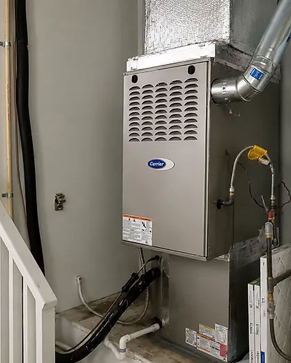 A furnace and water heater side by side in a basement