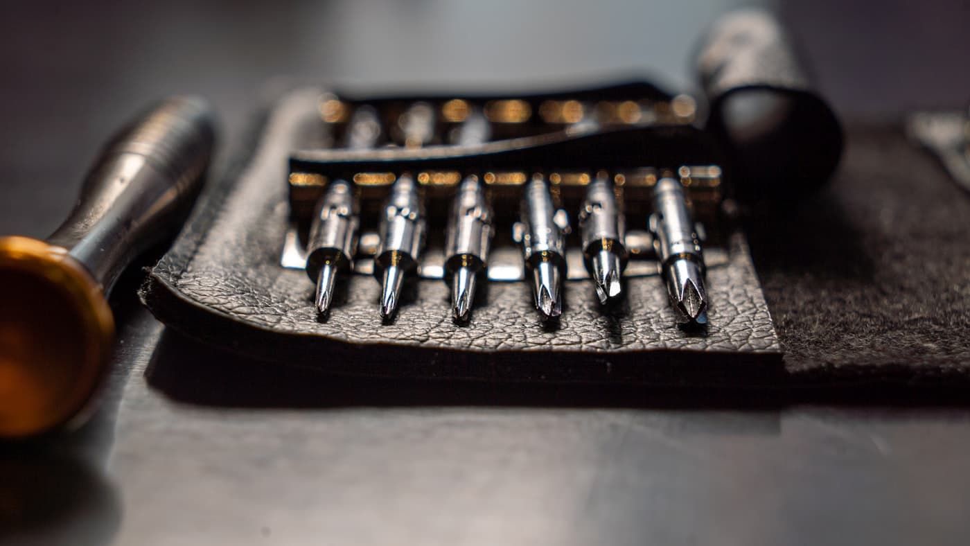 Machined driver bits laid out on a leather tool roll