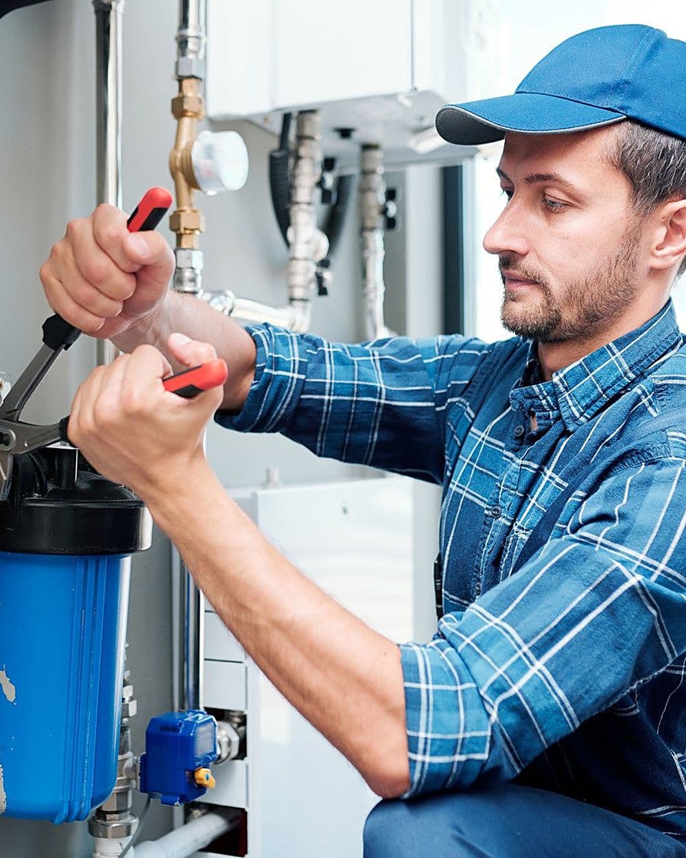 A plumber fitting a whole-house water filter